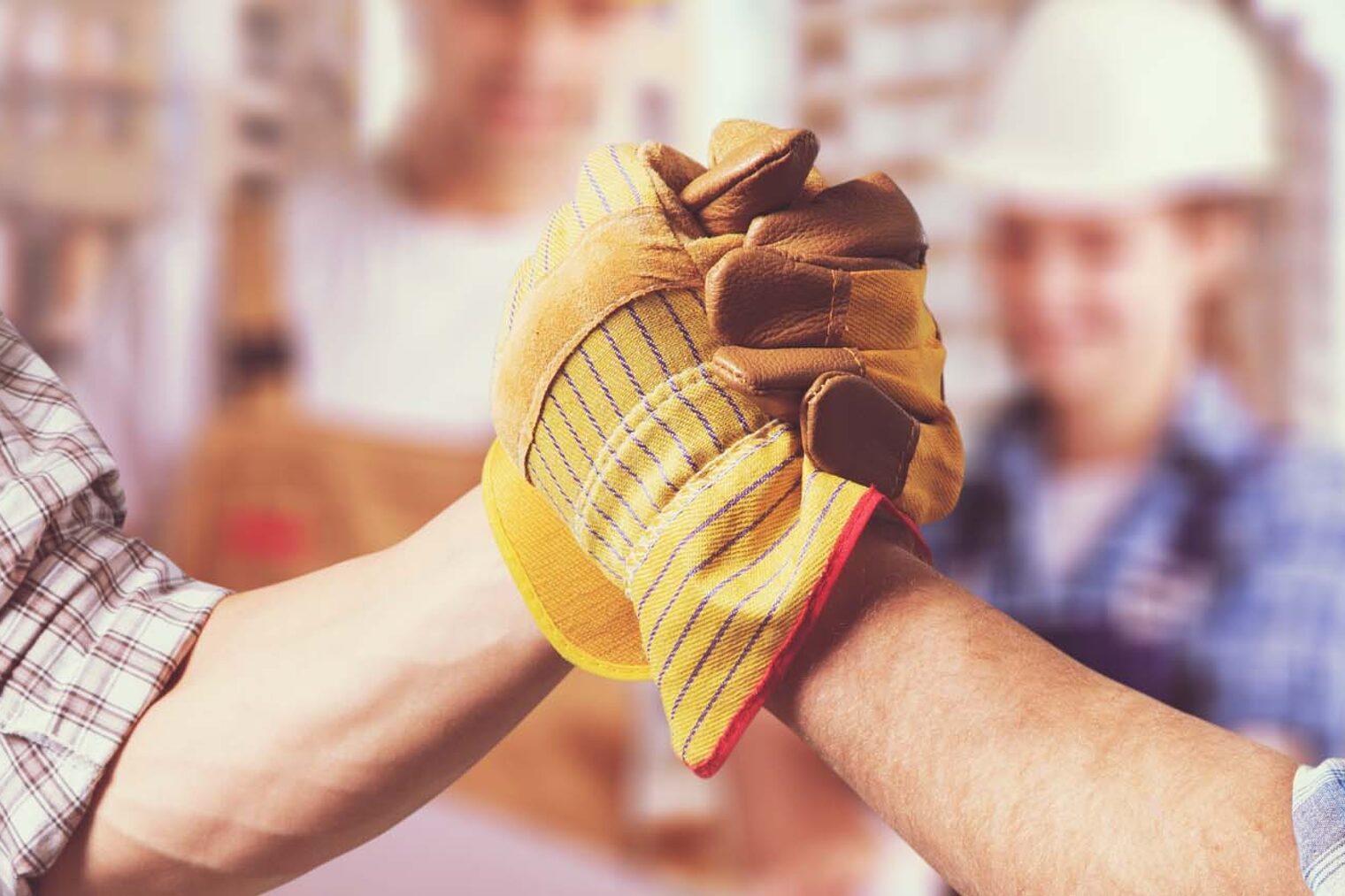 Zwei behandschuhte Hände schlagen ein