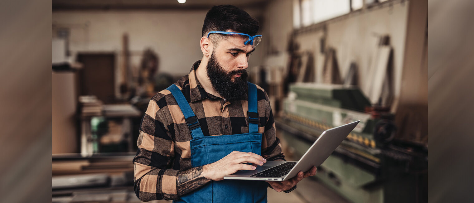 Mann in Werkstatt mit Laptop