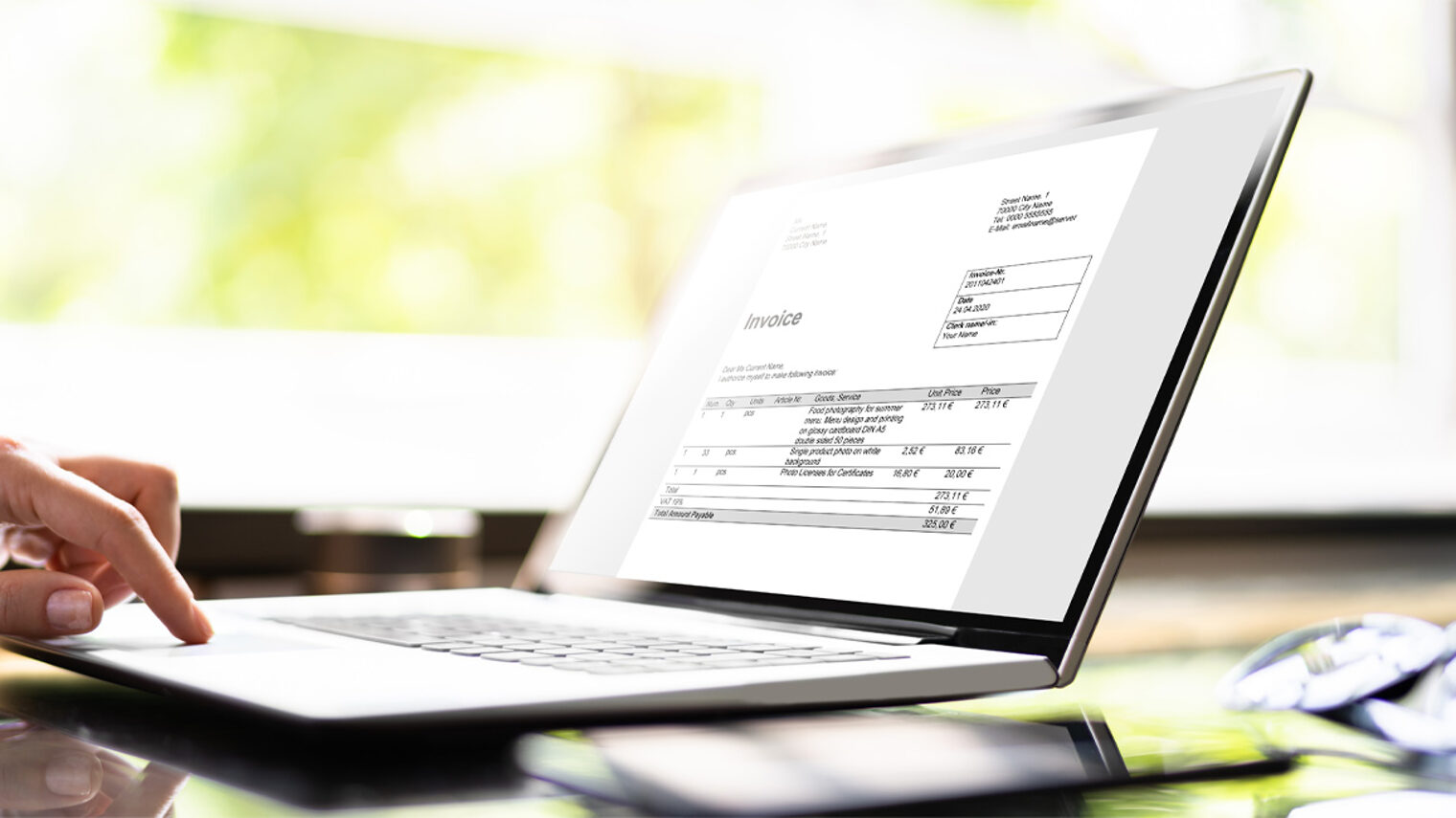 Laptop auf einem Tisch mit elektronischer Rechnung auf dem Bildschirm