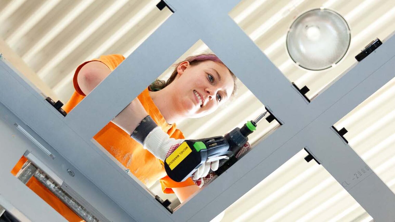 Schreinerin mit Bohrmaschine in der Hand