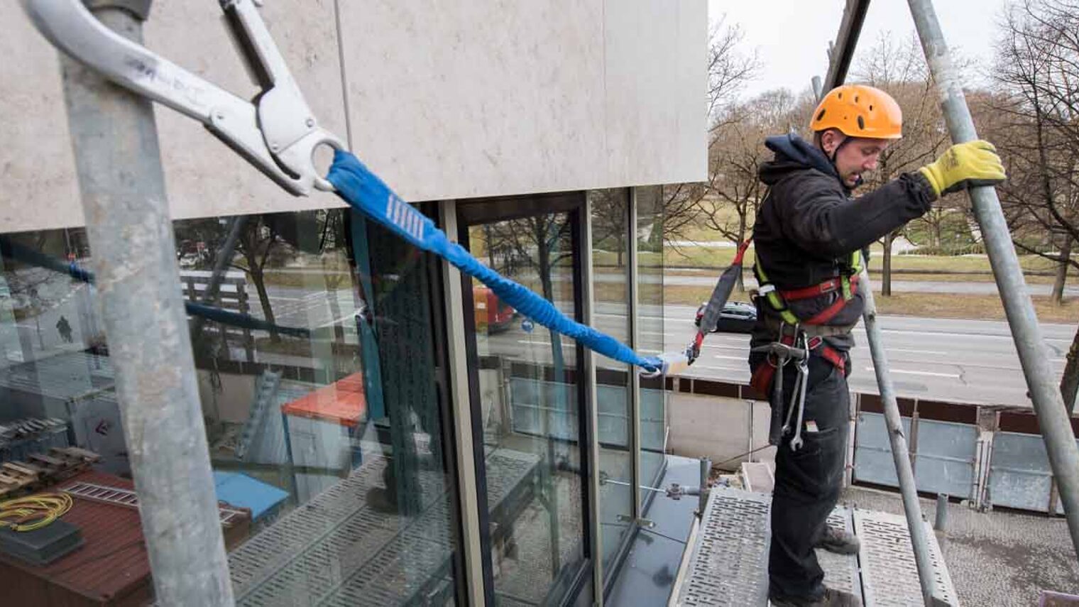 Handwerker auf einem Gerüst, er trägt einen Schutzhelm