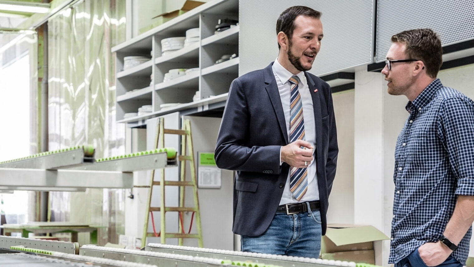 Berater und Betriebsinhaber in Werkstatt im Gespräch