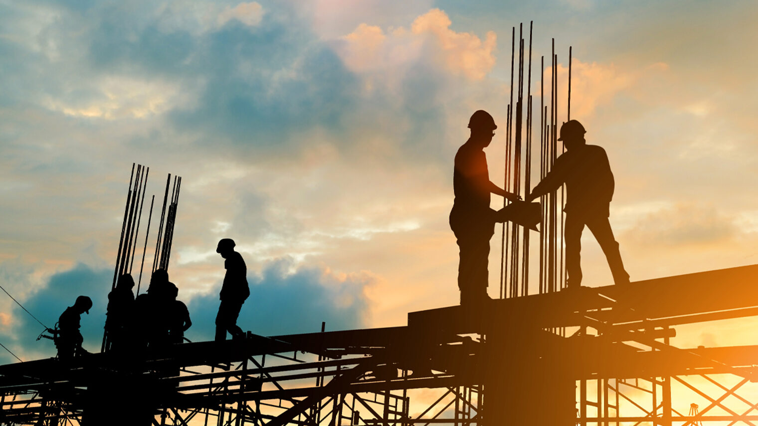 Totale eine Baustelle mit Bauarbeitern im Sonnenuntergang