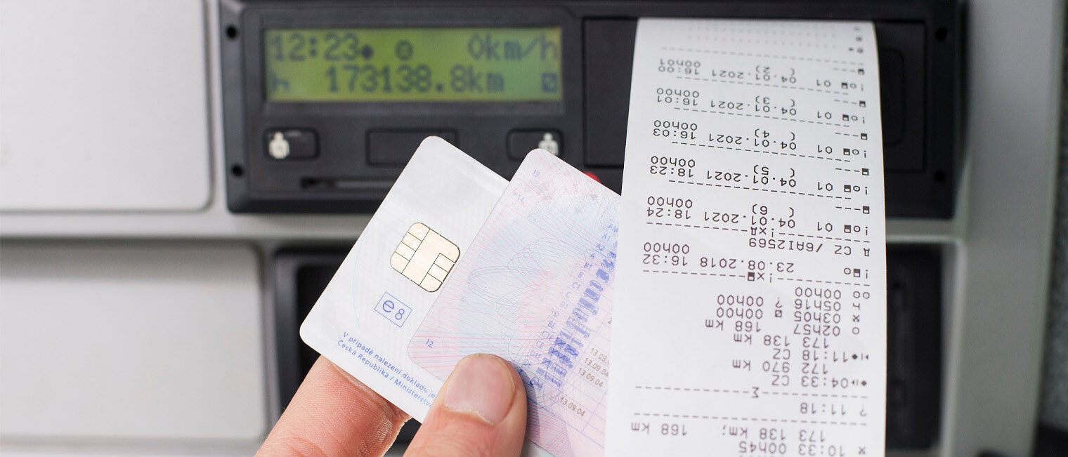 Digitaler Tachograph Nahaufnahme einer Hand vor einem digitalen Tachografen mit Karte und Ausdrucken