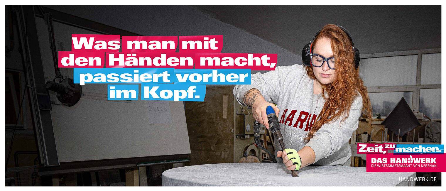 Imagekampagne des Handwerks Halbtotale eine Steinmetzin, die mit einem Bohrer eine Steinplatte bearbeitet.