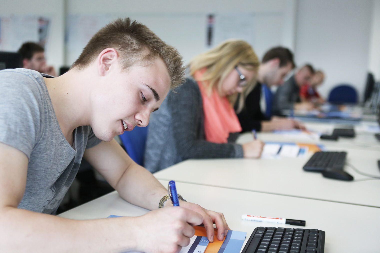 Kurse | Seminare Nahaufnahme von Schüler an einem Tisch, der mitschreibt