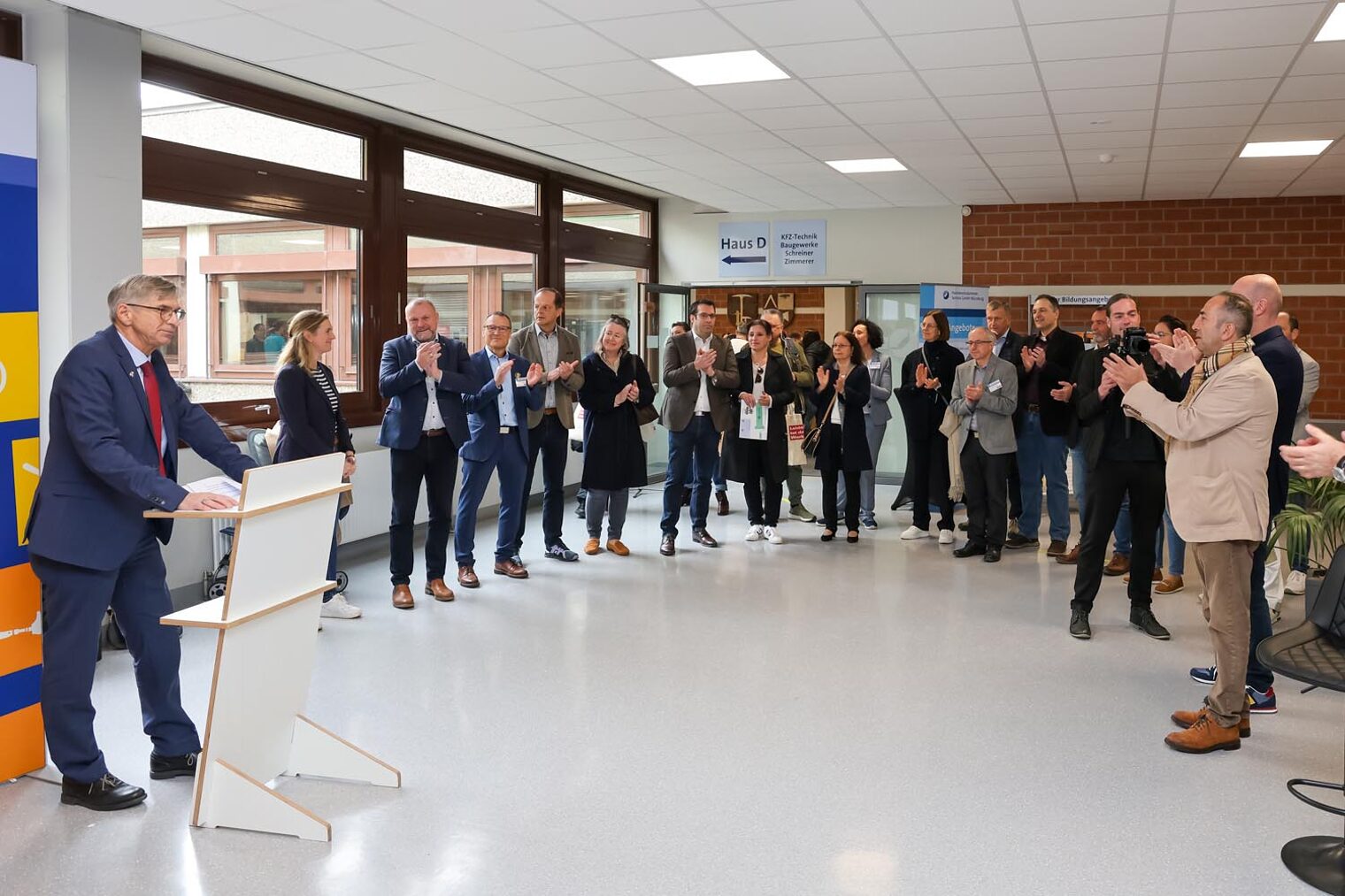 Eröffnung Macher-Tag 2025 Handwerkskammer-Präsident Michael Bissert am Rednerpult und Ehrengäste stehen im Halbkreis