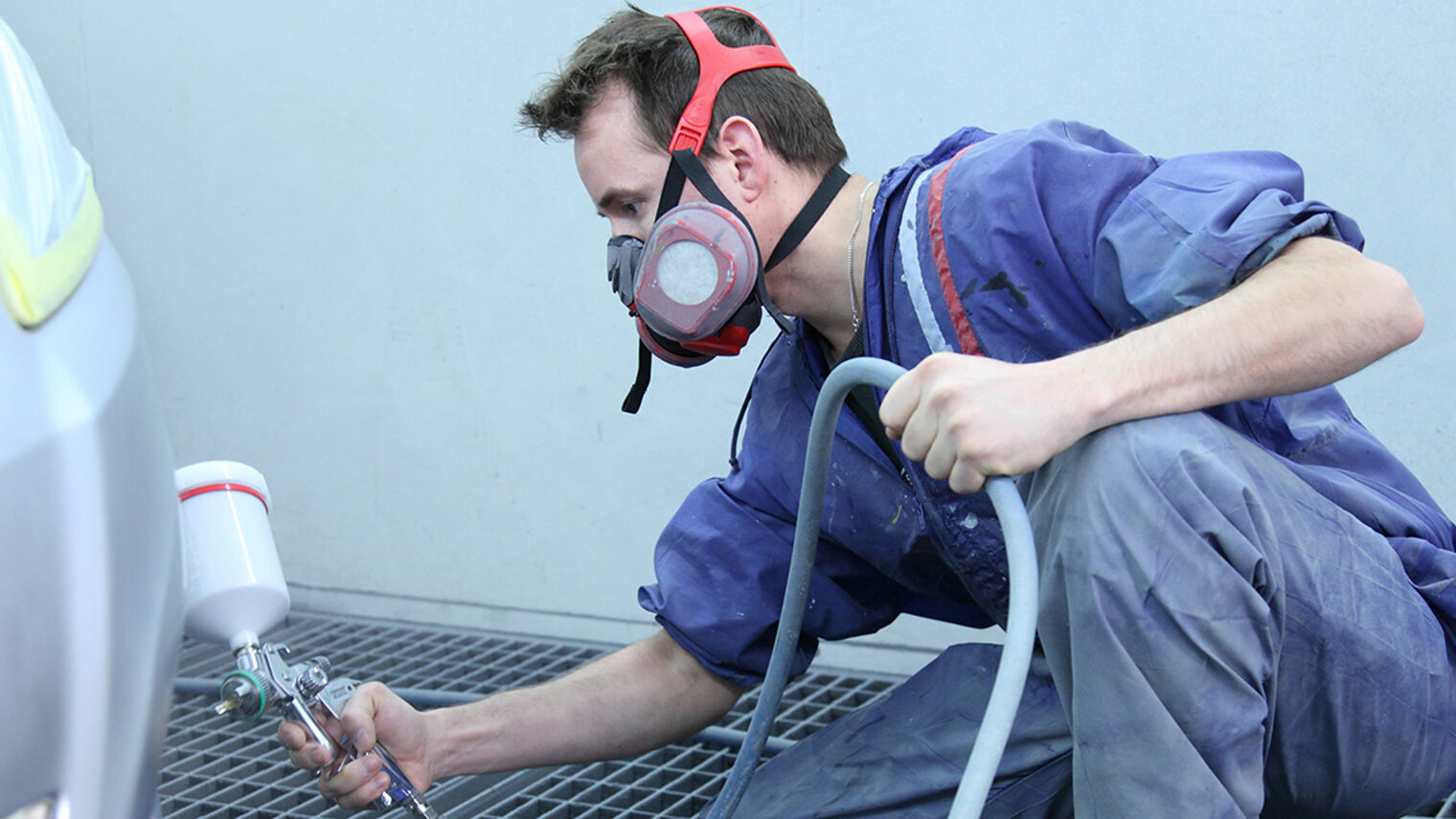 ÜLU-Ausbildungsbegleitender Kurs Fahrzeuglackierer/in in Aschaffenburg – Teilnehmer beim Lackieren eines Fahrzeugs