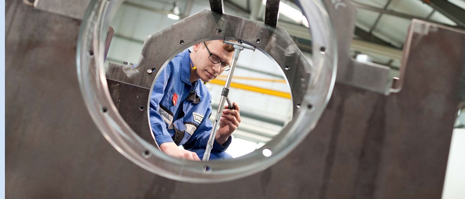 Metallbauer in Schutzkleidung richtet ein Stab aus Metallbauer in Schutzkleidung richtet ein Stab aus