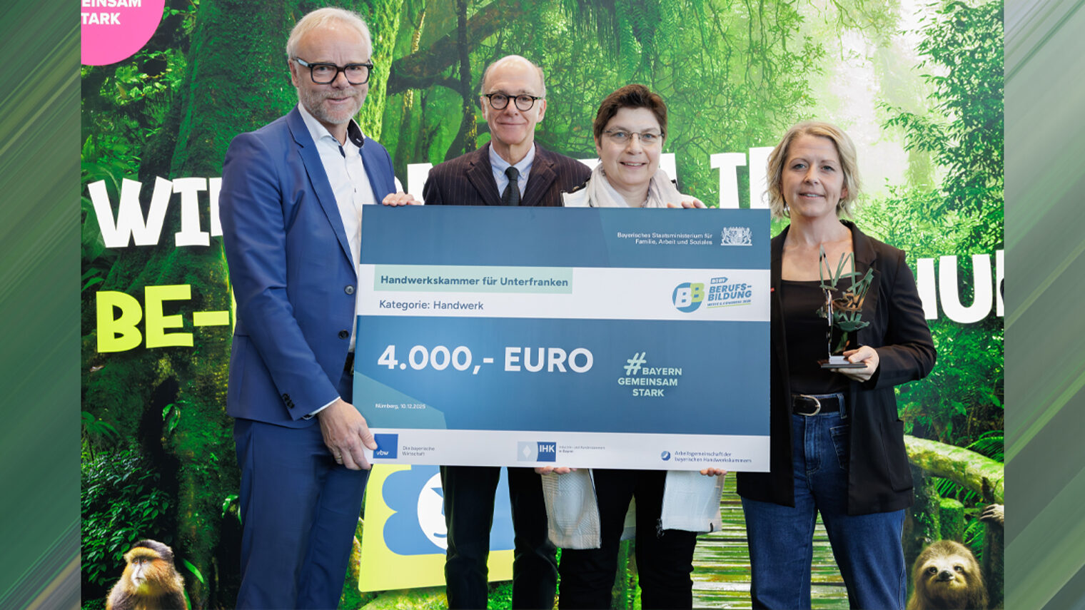 Gruppenfoto vier Personen mit Scheck und Aufschrift 4.000 Euro