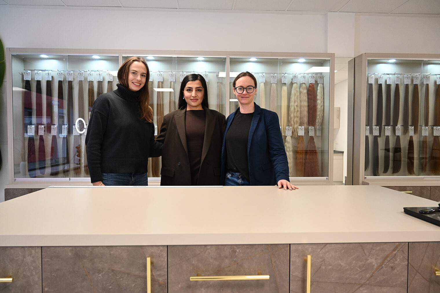 Drei Frauen stehen nebeneinander in einer Friseurgeschäft