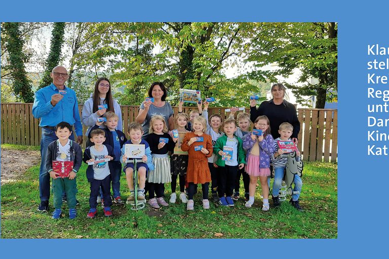 Gruppenbild - jubelnde Kinder mit Erwachsnenen stehen im Garten, daneben ein Textfeld mit den Namen.